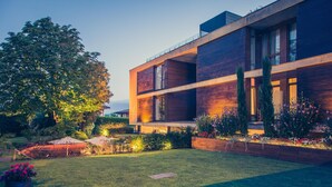 A modern building with a well-maintained garden and outdoor seating area.