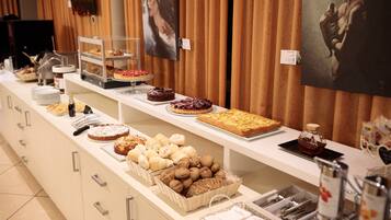 Um buffet com diversos produtos de panificação e doces.