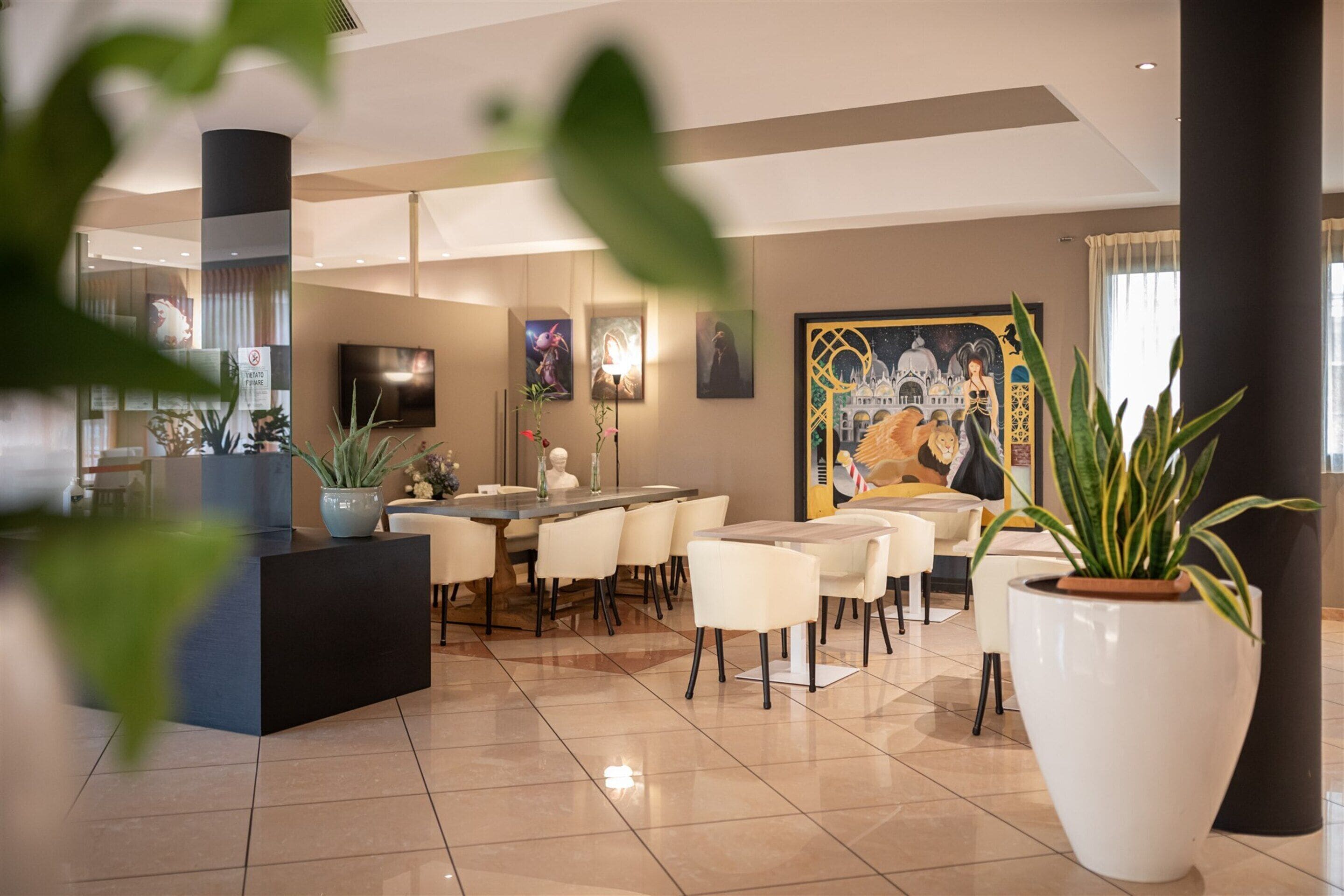 Un vestíbul d'hotel modern amb taulell de recepció, zona de seients i obres d'art a les parets.