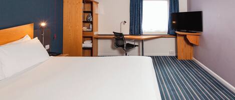 A hotel room with a bed, a desk, a chair, a television, and a wardrobe.