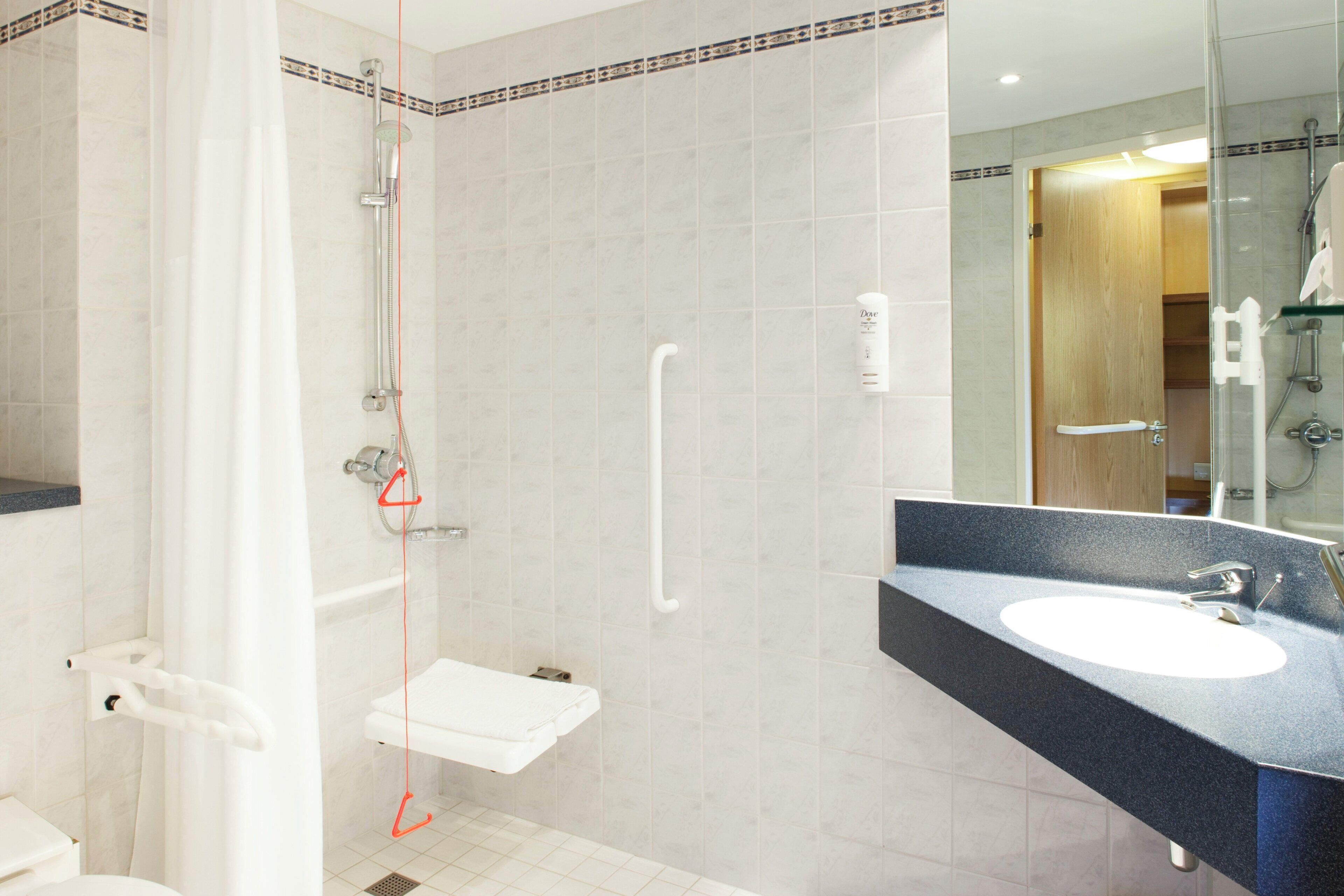 A modern bathroom with a shower, toilet, and sink.