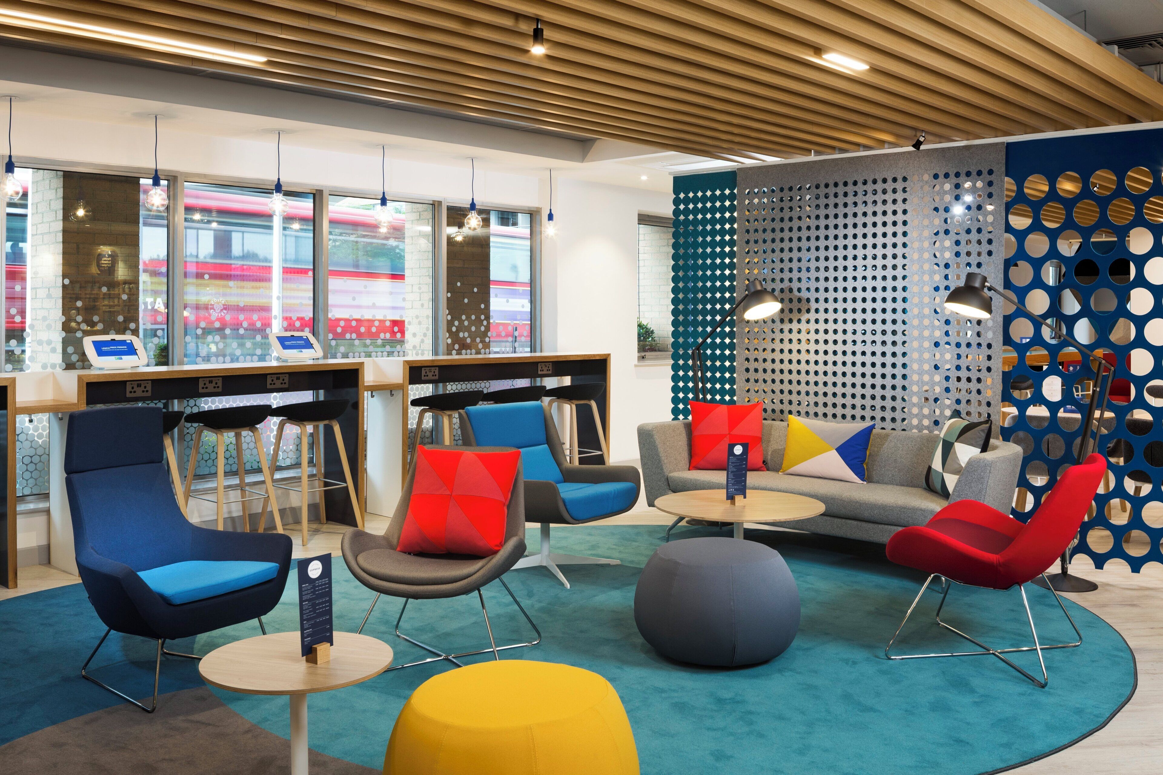 A modern lounge area with seating, tables, and a decorative wall.