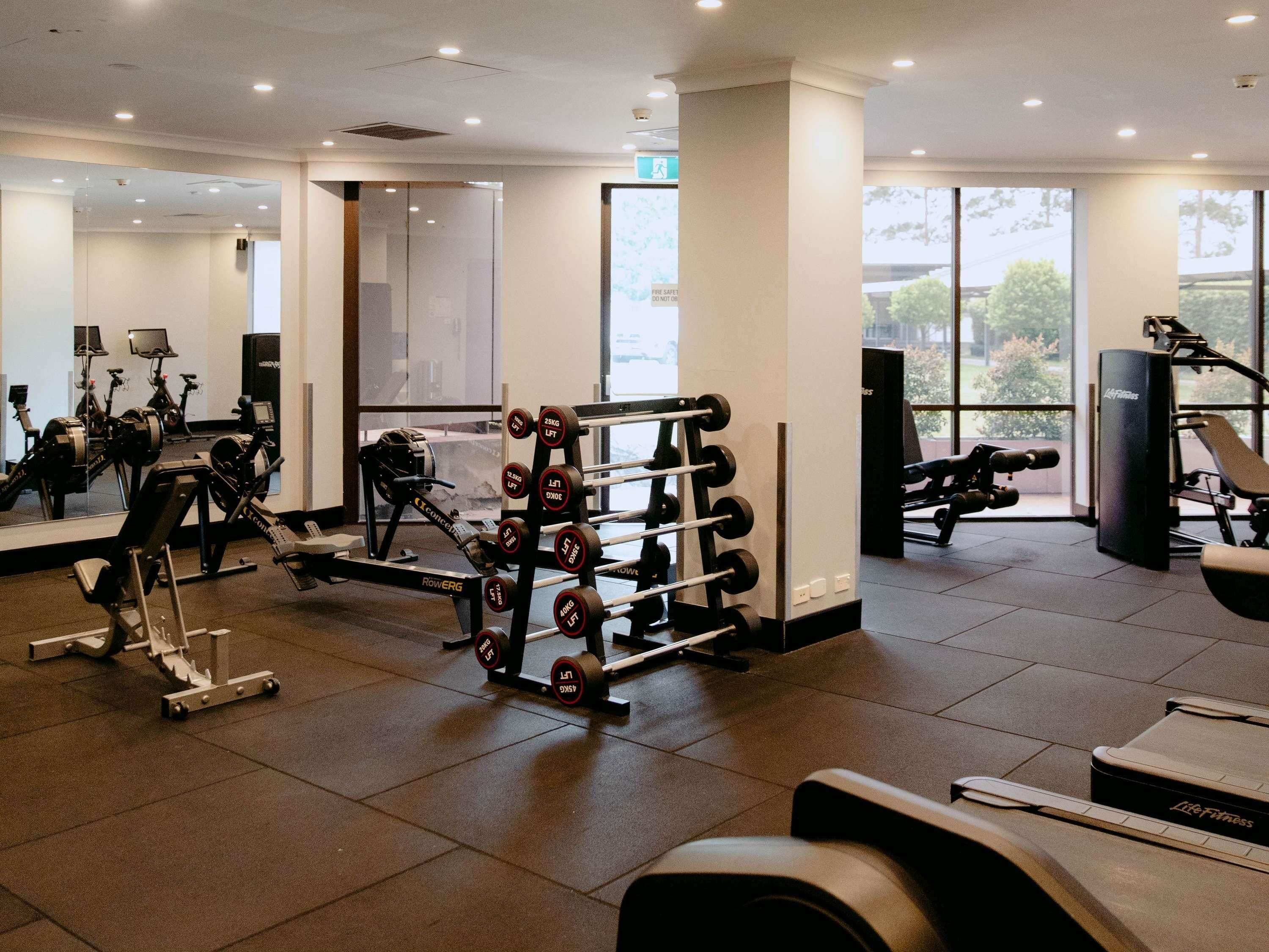 A gym with various exercise equipment, including treadmills, weight machines, and free weights.