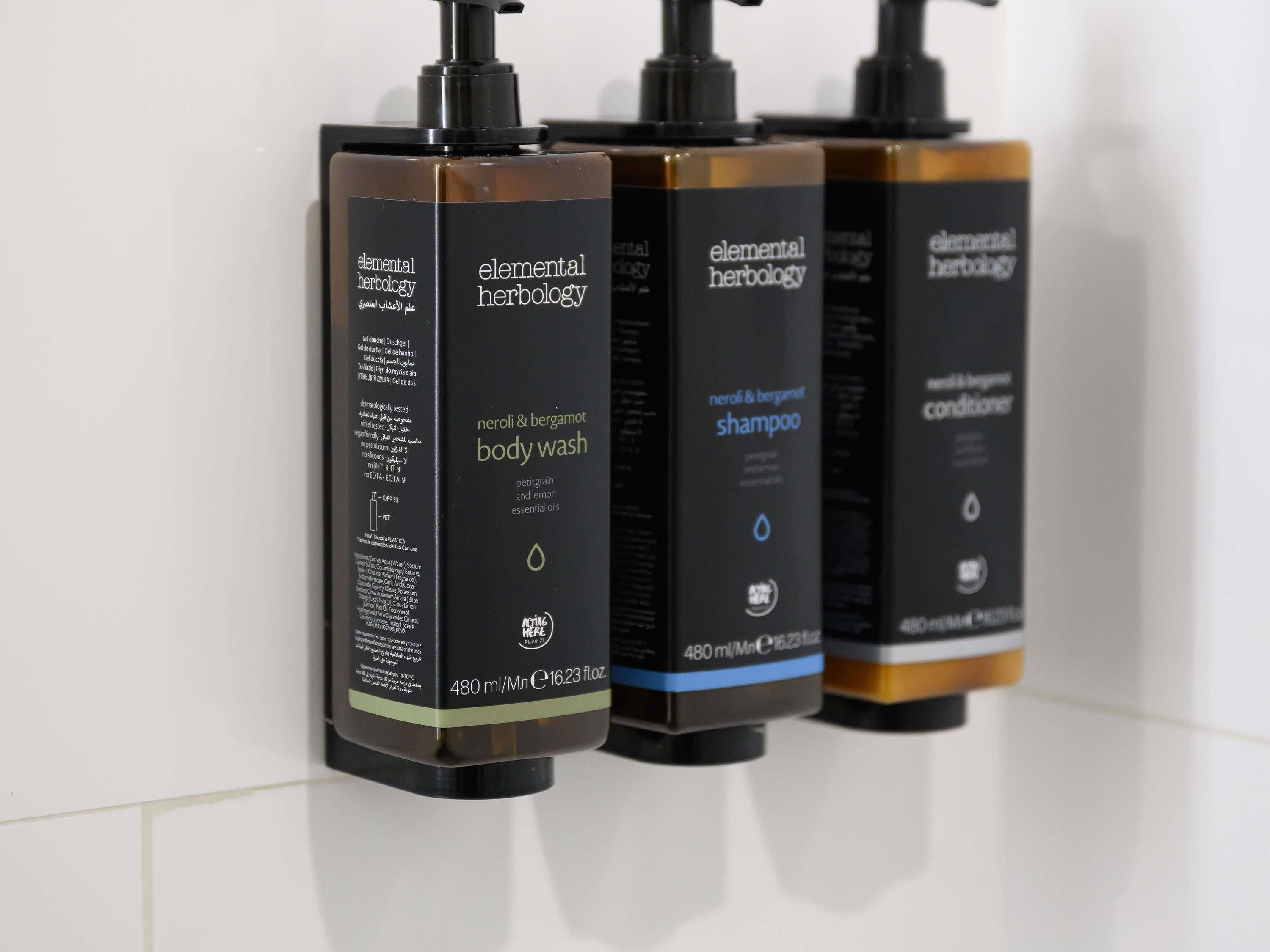 Tres botellas de productos Elemental Herbology: jabón corporal, champú y acondicionador.