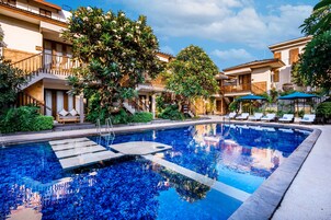 Una piscina al aire libre, sillones reclinables de piscina