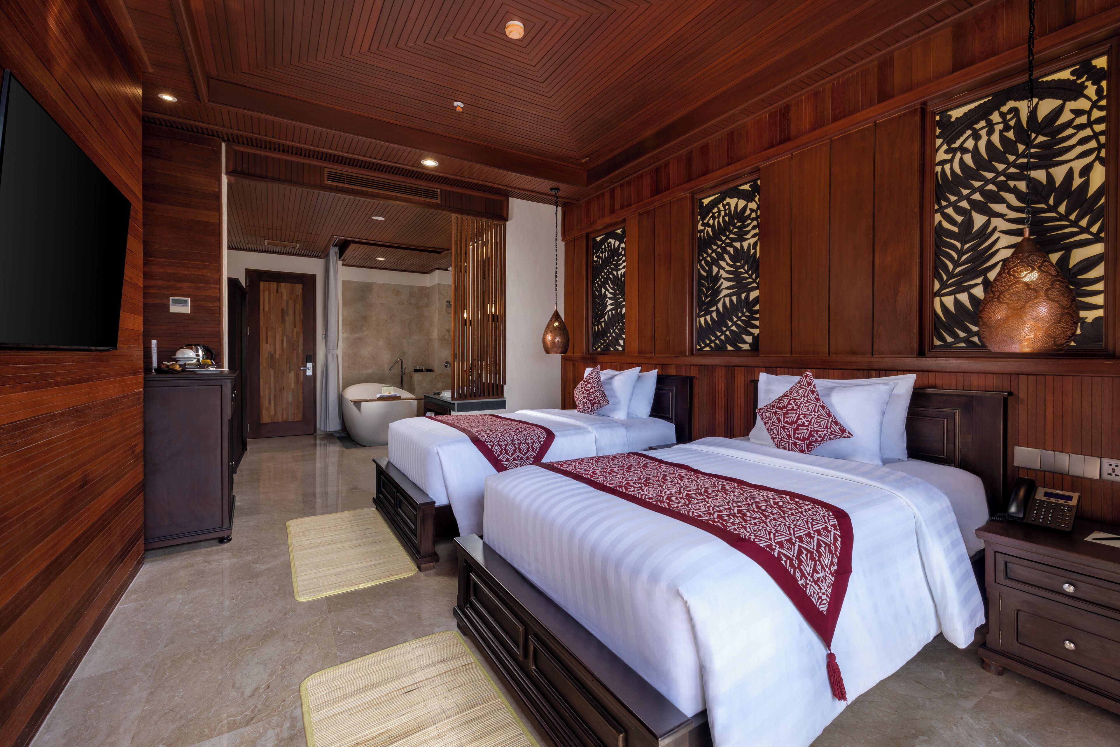 Habitación de hotel con dos camas, paneles de madera, una obra de arte grande y un televisor de pantalla plana.