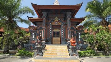Un templo tradicional con arquitectura ornamentada, una entrada central y estatuas a ambos lados.