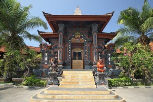 Un templo tradicional con arquitectura ornamentada, una entrada central y estatuas a ambos lados.