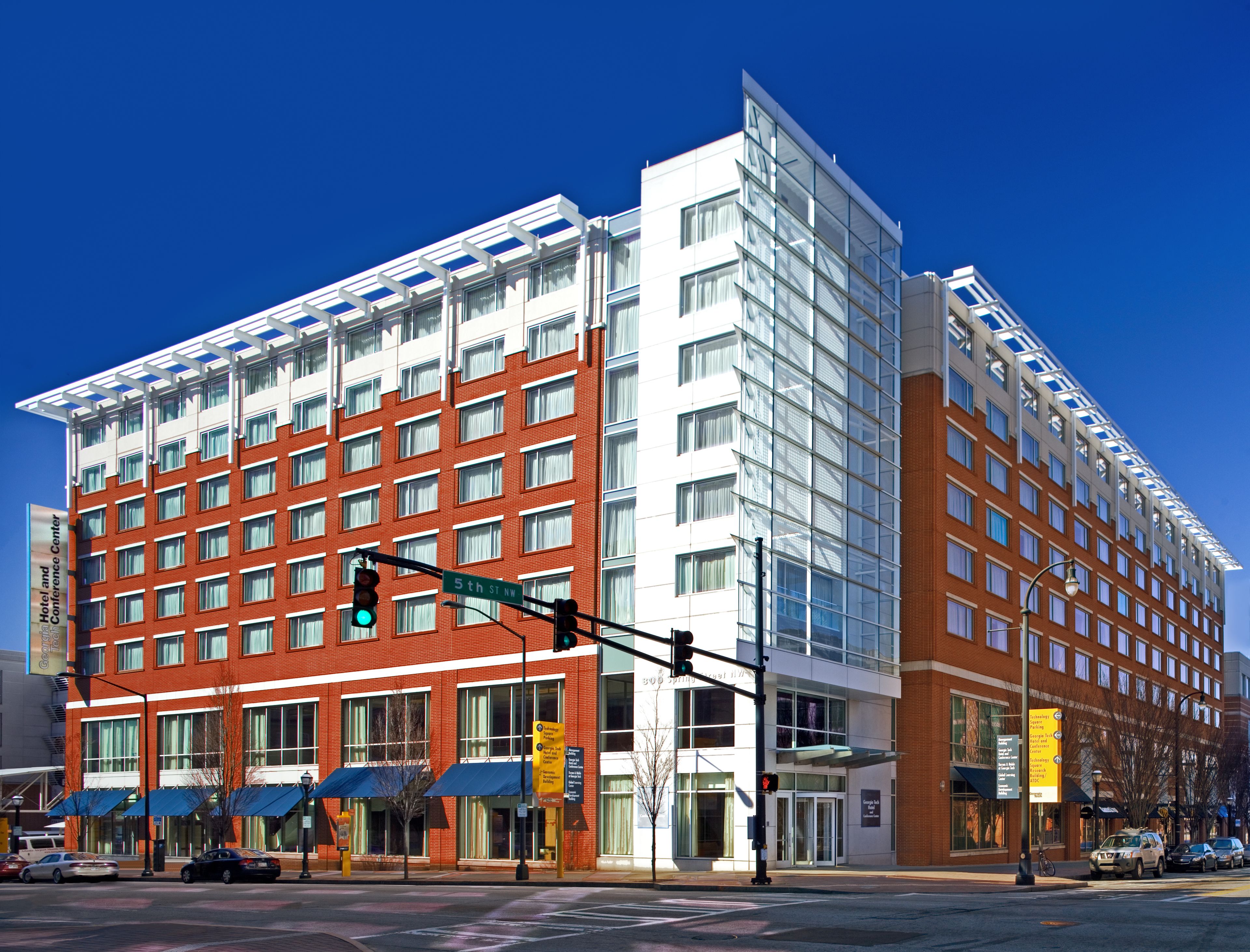 A multi-story hotel with a red brick facade and large windows.