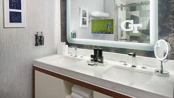 Un baño moderno con dos lavamanos, un espejo grande y un perchero para toallas.