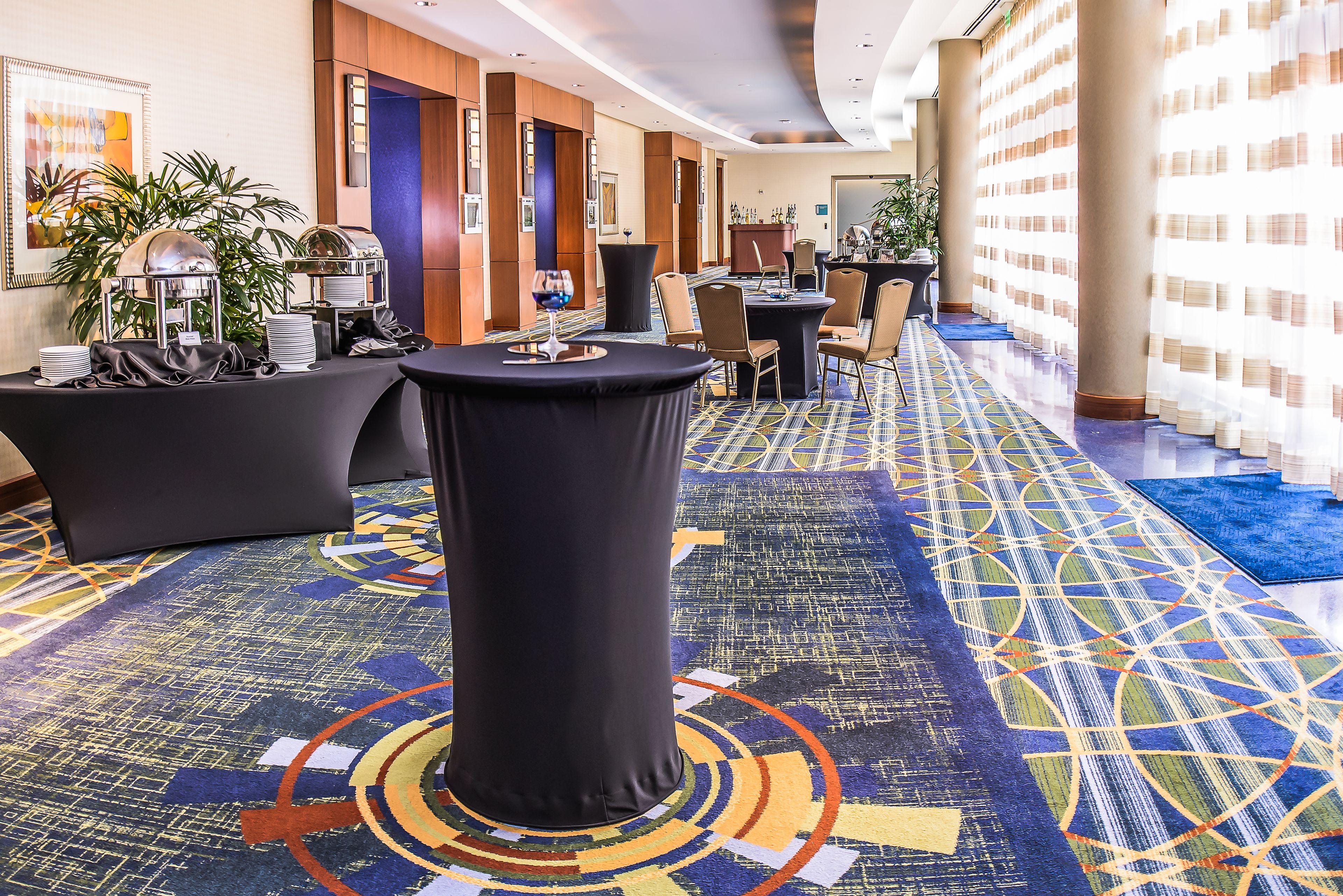 Eine Hotelhalle mit Rezeption, Sitzgelegenheiten und einem gemusterten Teppich.