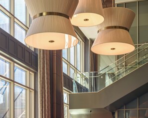 A modern interior with large windows, a staircase, and multiple hanging lamps. - Georgia Tech Hotel and Conference Center (Atlanta)