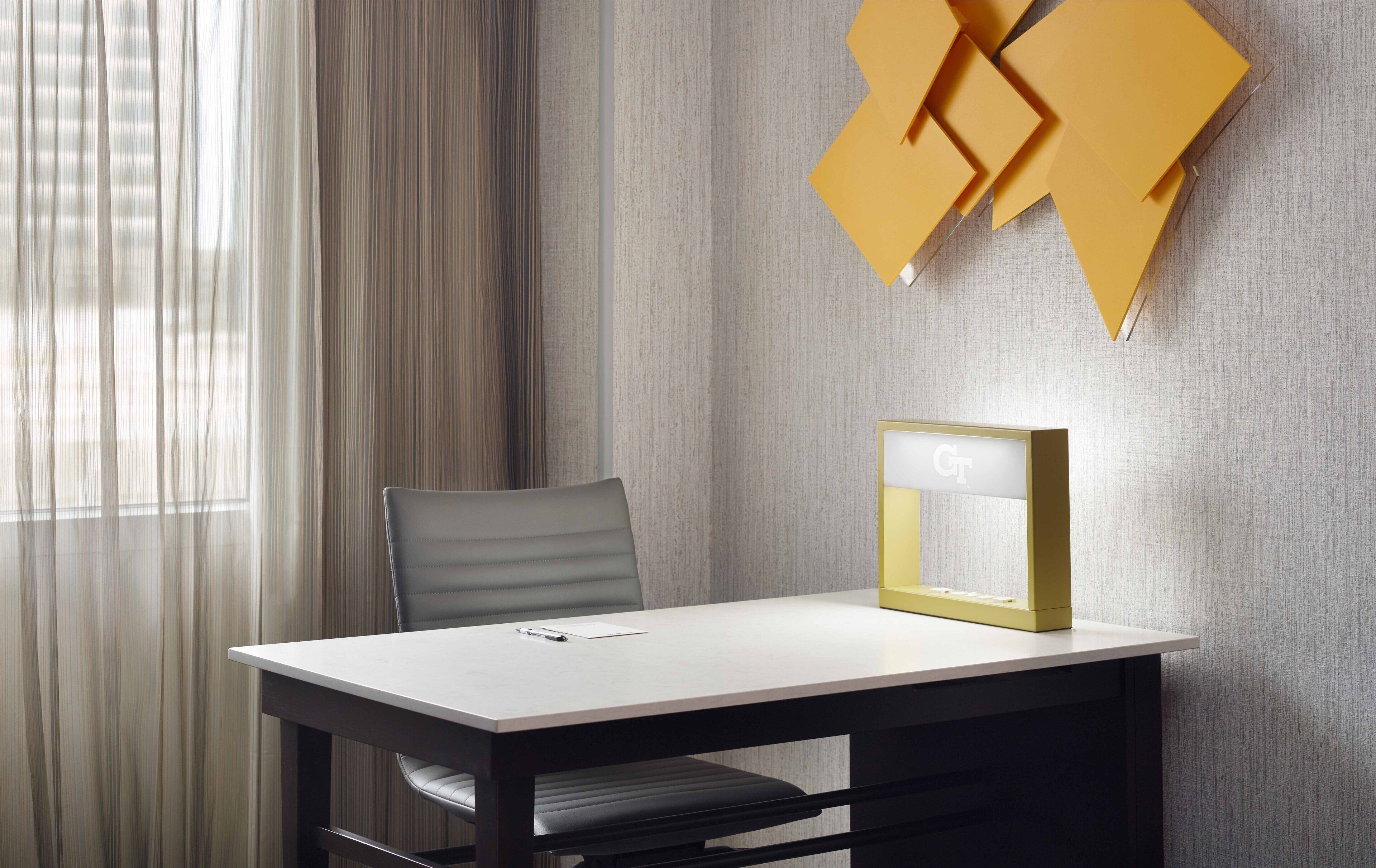 Una habitación moderna con una mesa, una silla y un aplique de pared.