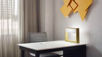 Una habitación moderna con una mesa, una silla y un aplique de pared.