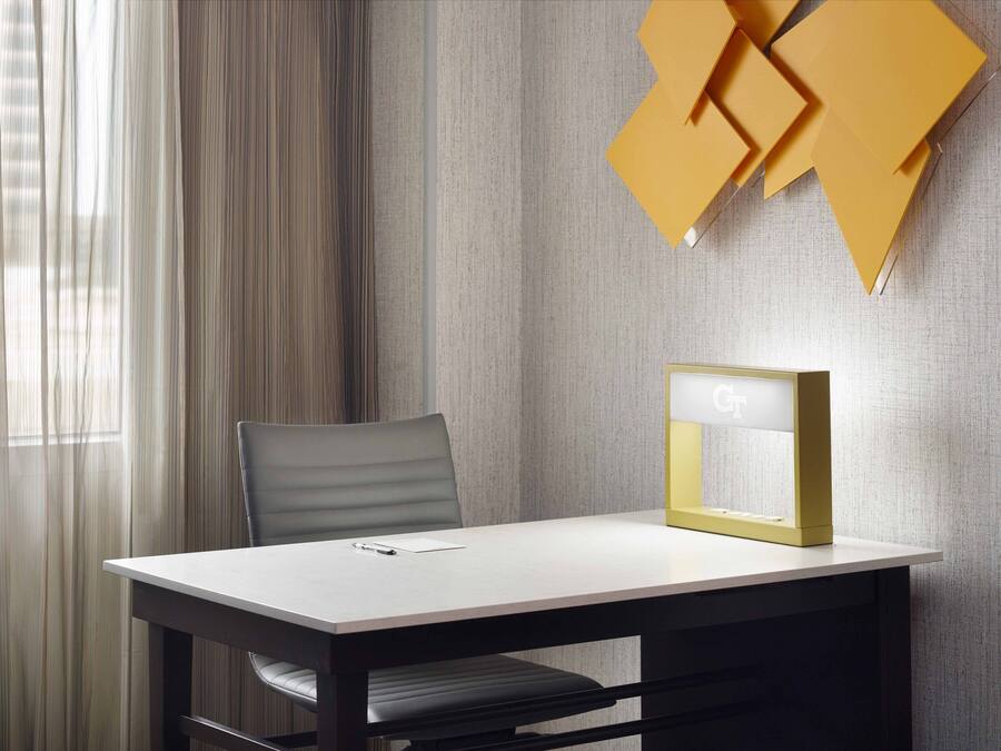 Una habitación moderna con una mesa, una silla y un aplique de pared.