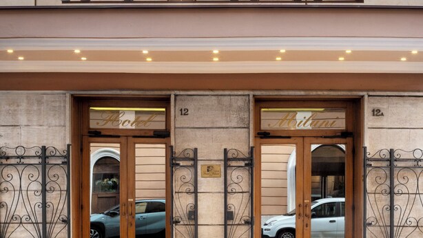 A hotel entrance with the name 'MILANI' in large letters, double doors, and a balcony with a railing. - Hotel Milani (Rome)