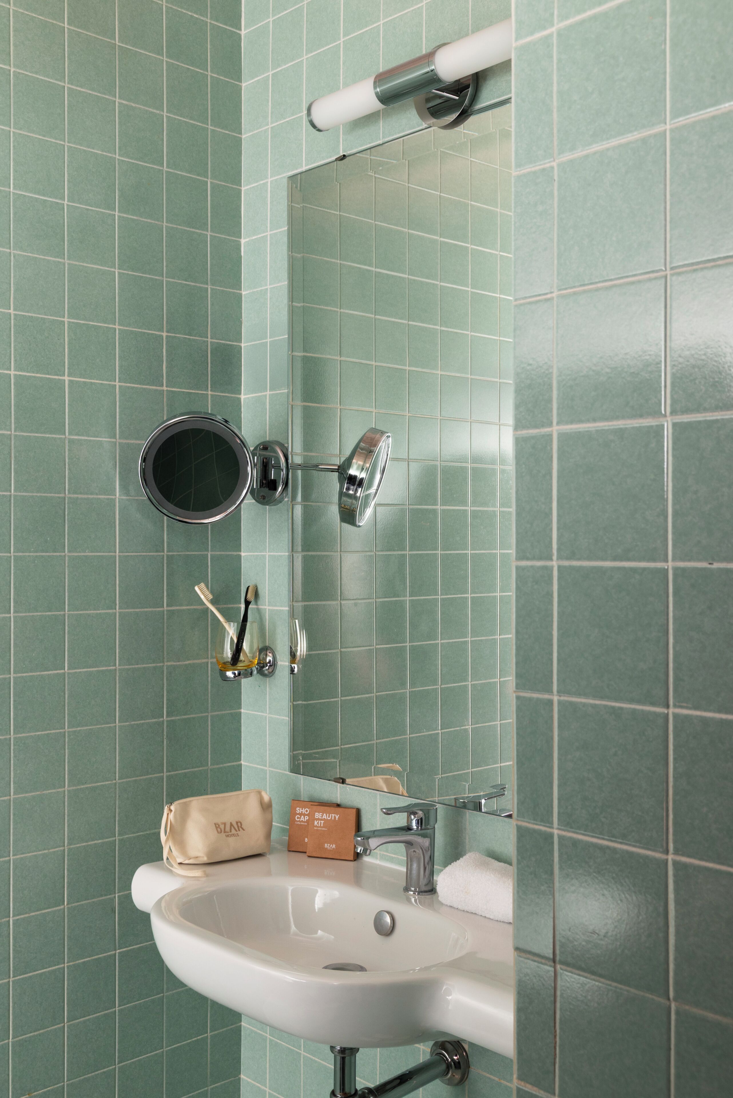 Un baño con lavamanos, espejo y artículos de aseo.