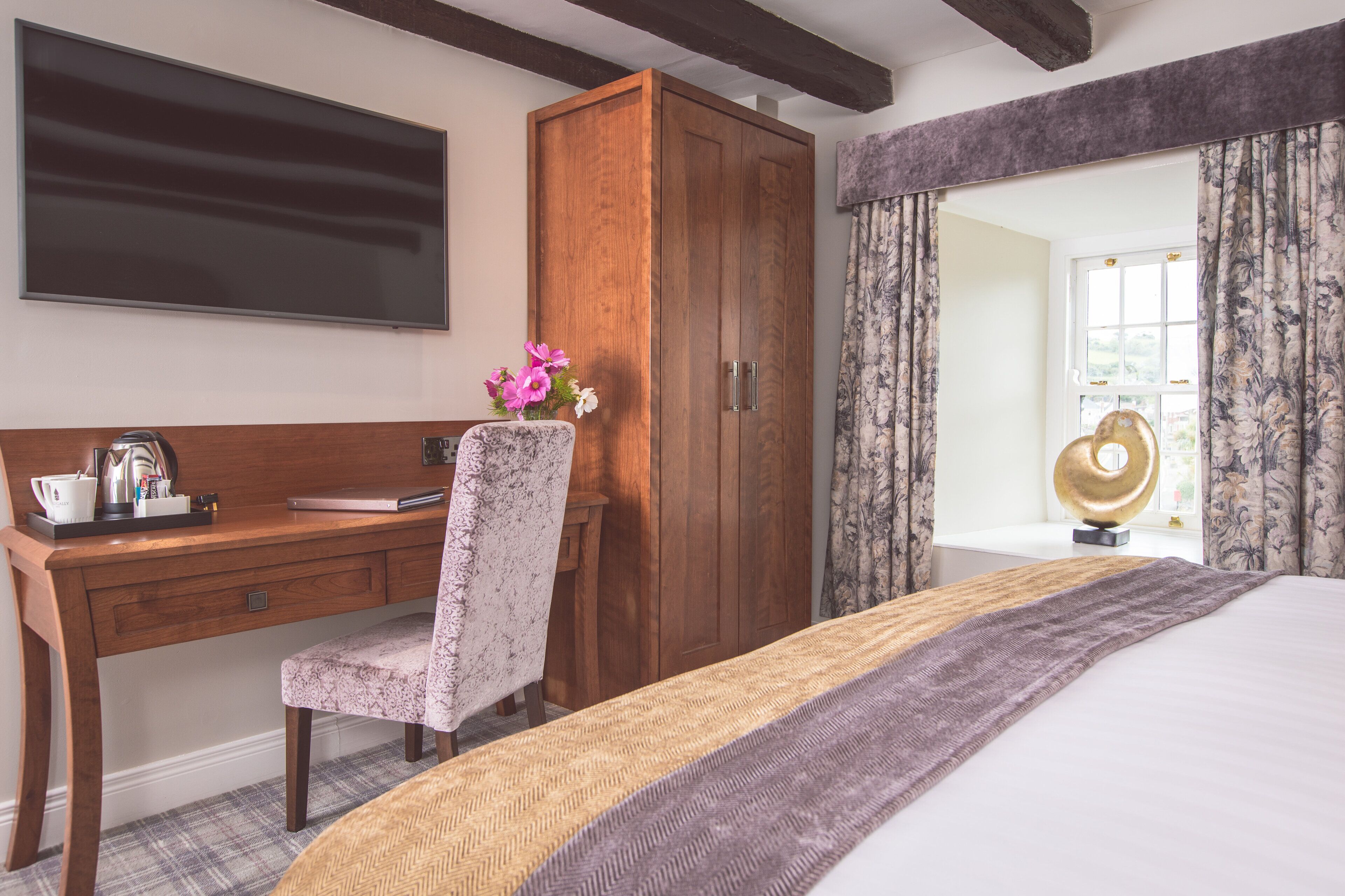 Une chambre à coucher avec un bureau en bois, une chaise, un lit et une armoire.