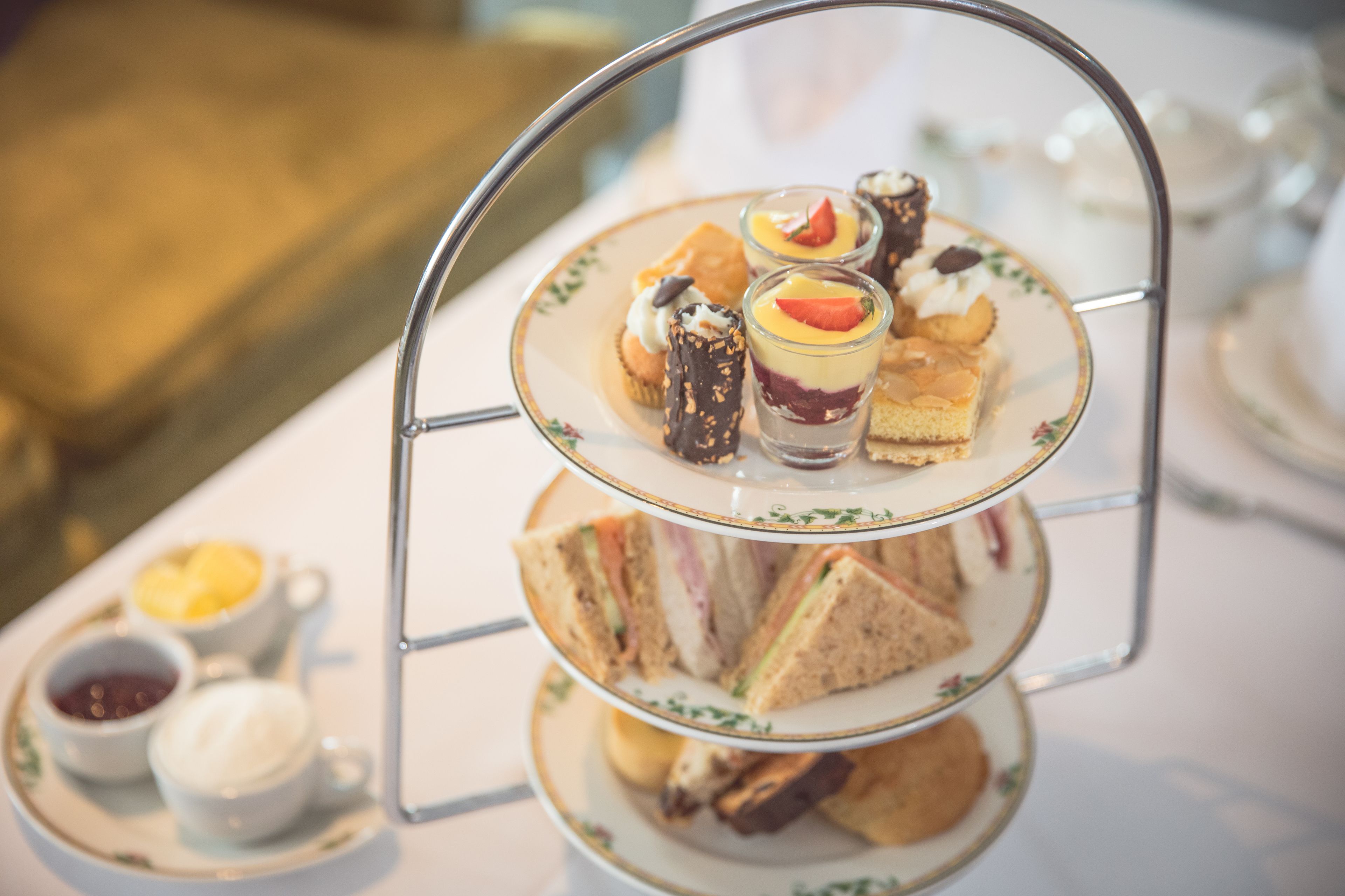 A three-tiered dessert stand with various pastries and desserts.