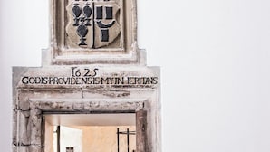Un arco de piedra con un escudo de armas y la inscripción '1625 GODISPROVIDENSIMY IN HERITANS'.