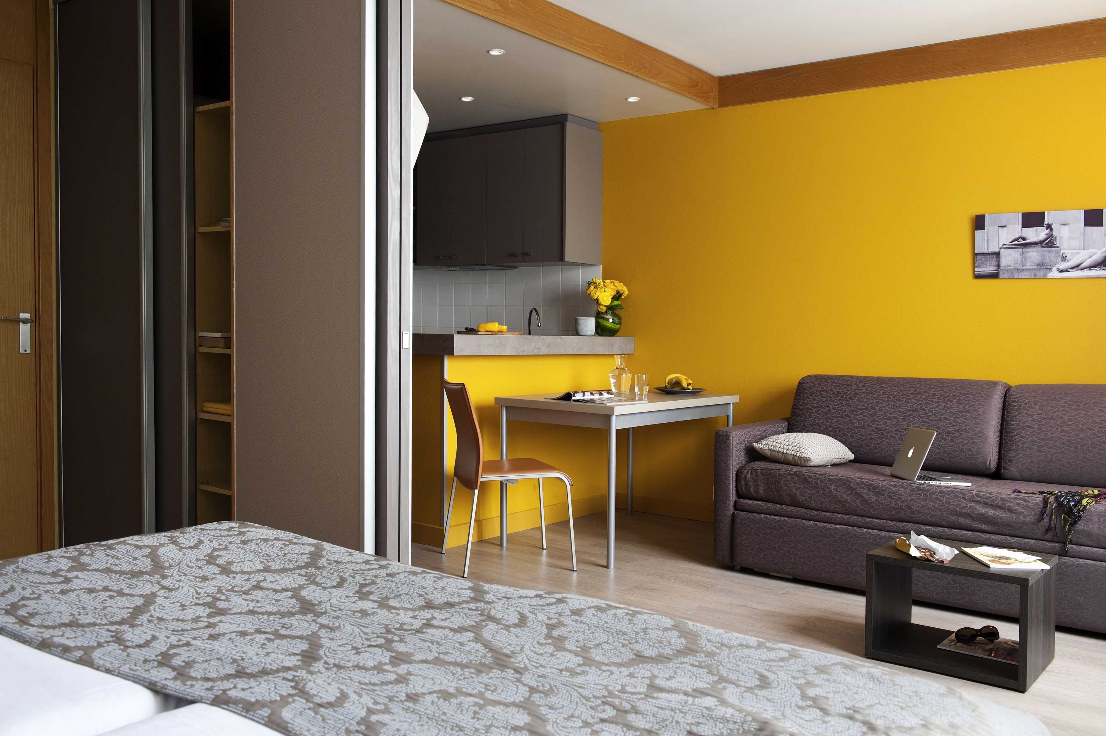 A compact living space with a bed, a dining area, and a sofa.