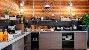 Una cocina moderna con paredes de madera, una isla central con diversos alimentos y iluminación sobre la encimera.