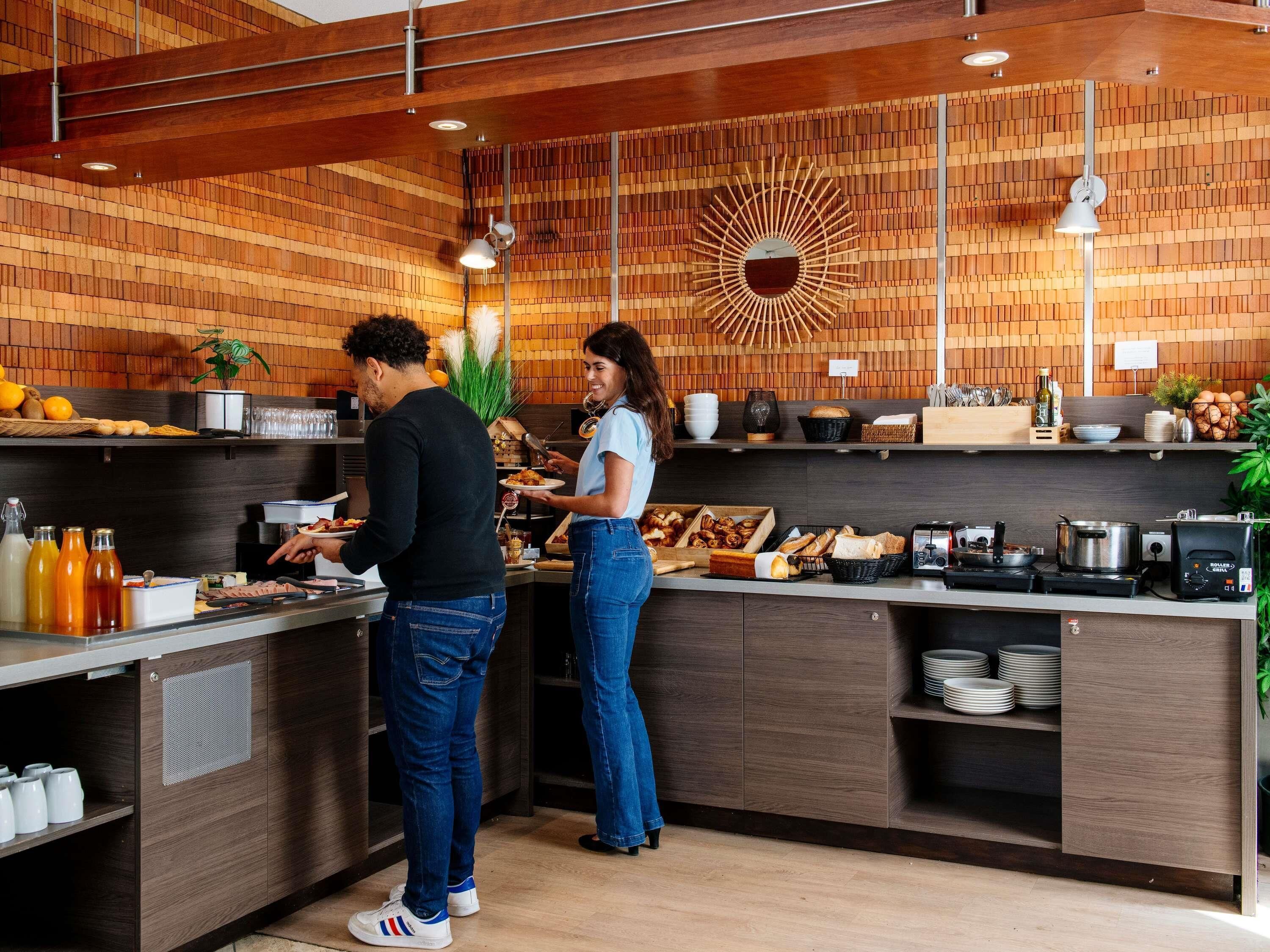 Una cocina moderna con detalles de madera, estufa integrada y un elemento decorativo en la pared.