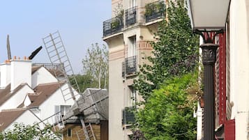 A building with a windmill, a street lamp, and a tree.