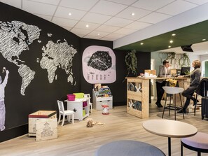 Een modern interieur met een wereldkaart muurschildering, een bar en een zithoek.