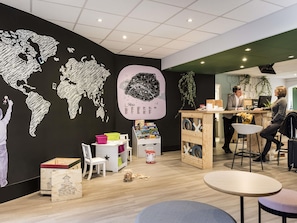 Un intérieur moderne agrémenté d’une fresque représentant une carte du monde, d’un espace bar et d’un coin salon.