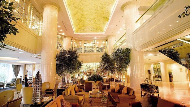 A spacious lobby with high ceilings, large columns, and a central seating area with sofas and tables. - Beijing Jinjiang Fuyuan Hotel (Beijing)