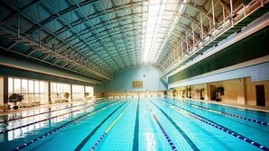 An indoor swimming pool with clear lanes, a high ceiling, and a view of the outside through large windows. - Beijing Jinjiang Fuyuan Hotel (Beijing)