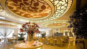 A spacious hotel lobby with a central round table, multiple seating areas, and a decorative ceiling with intricate patterns. - Beijing Jinjiang Fuyuan Hotel (Beijing)