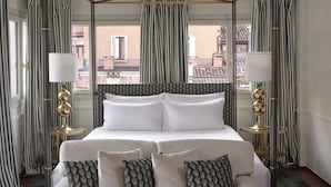 A hotel room with a large bed, striped curtains, and two bedside lamps. - Violino D’Oro Venezia (Venice)