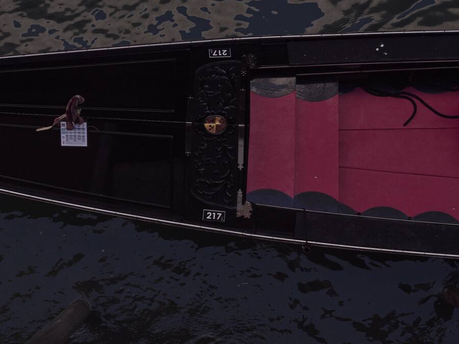 Um barco com uma placa de número 217, uma porta decorativa e uma pequena figura humana.