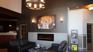 Ein moderner Lounge-Bereich mit Ledersofas, einem Flachbildfernseher, einem Kamin und einem Geldautomaten der Bank.