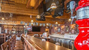 Eine Bar mit Holzmöbeln, einem roten Neonlicht und einem an der Wand befestigten Fernseher.