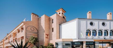 Ein Hotel im traditionellen Baustil, mit einem markanten Turm und Rundbogenfenstern.