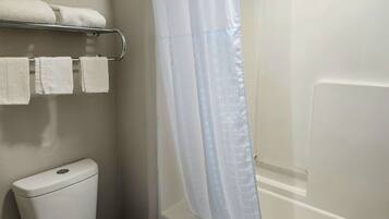 Un baño con inodoro, toallero y cortina de ducha.