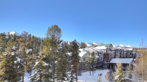 A snow-covered lodge with multiple buildings, surrounded by trees and mountains in the background. - Trails End Condominiums by Great Western Lodging (Breckenridge)