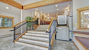 A staircase with wooden railings and a refrigerator on the landing. - Trails End Condominiums by Great Western Lodging (Breckenridge)