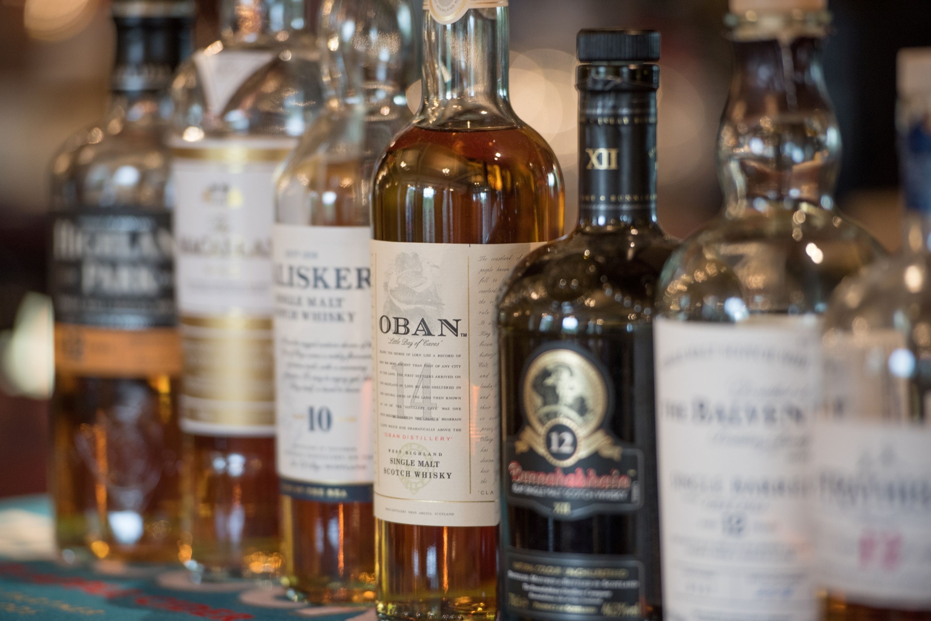 Diverse whiskyflessen staan op een tafel.