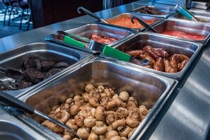 A buffet with various food items including sausages, mushrooms, and other dishes. - Cumbria Grand Hotel (Grange-over-Sands)