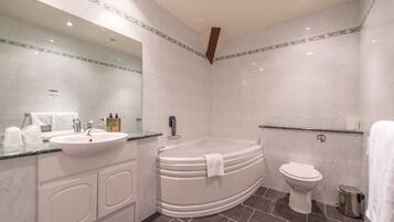 A modern bathroom with a freestanding bathtub, a sink, and a toilet.