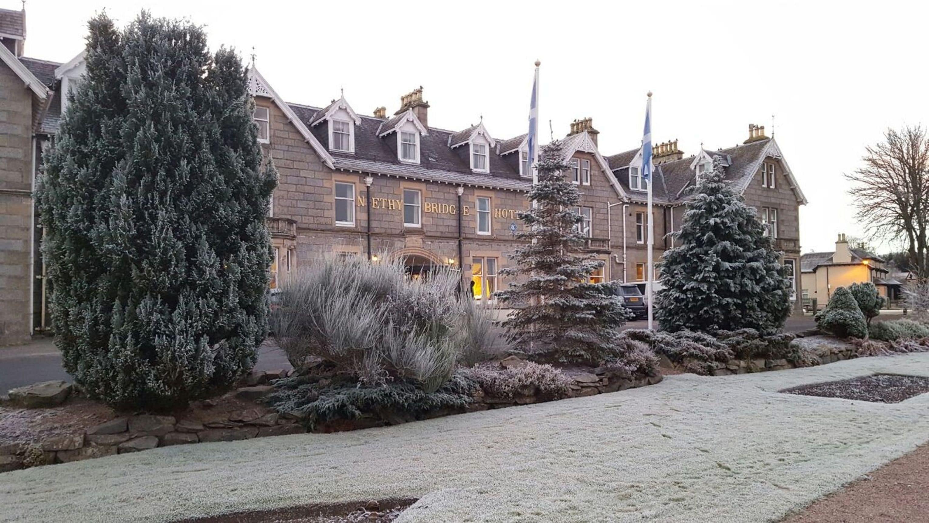 A traditional stone building with a sign reading "NETHY BRIDGE HOTEL".