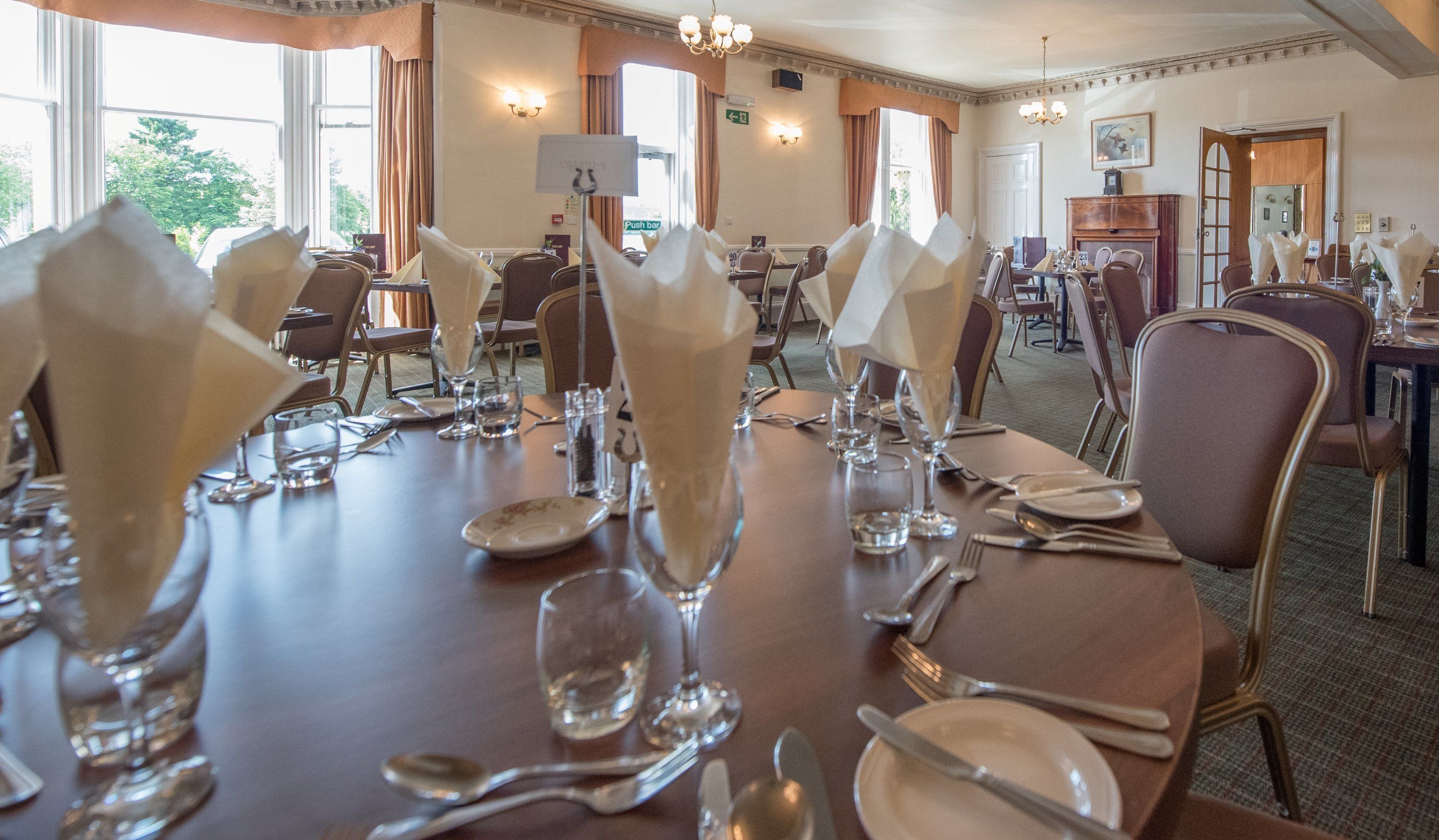 A dining area with tables set for a meal, including cutlery and glassware.