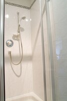 Una ducha con cabezal de ducha de mano y grifo empotrado.