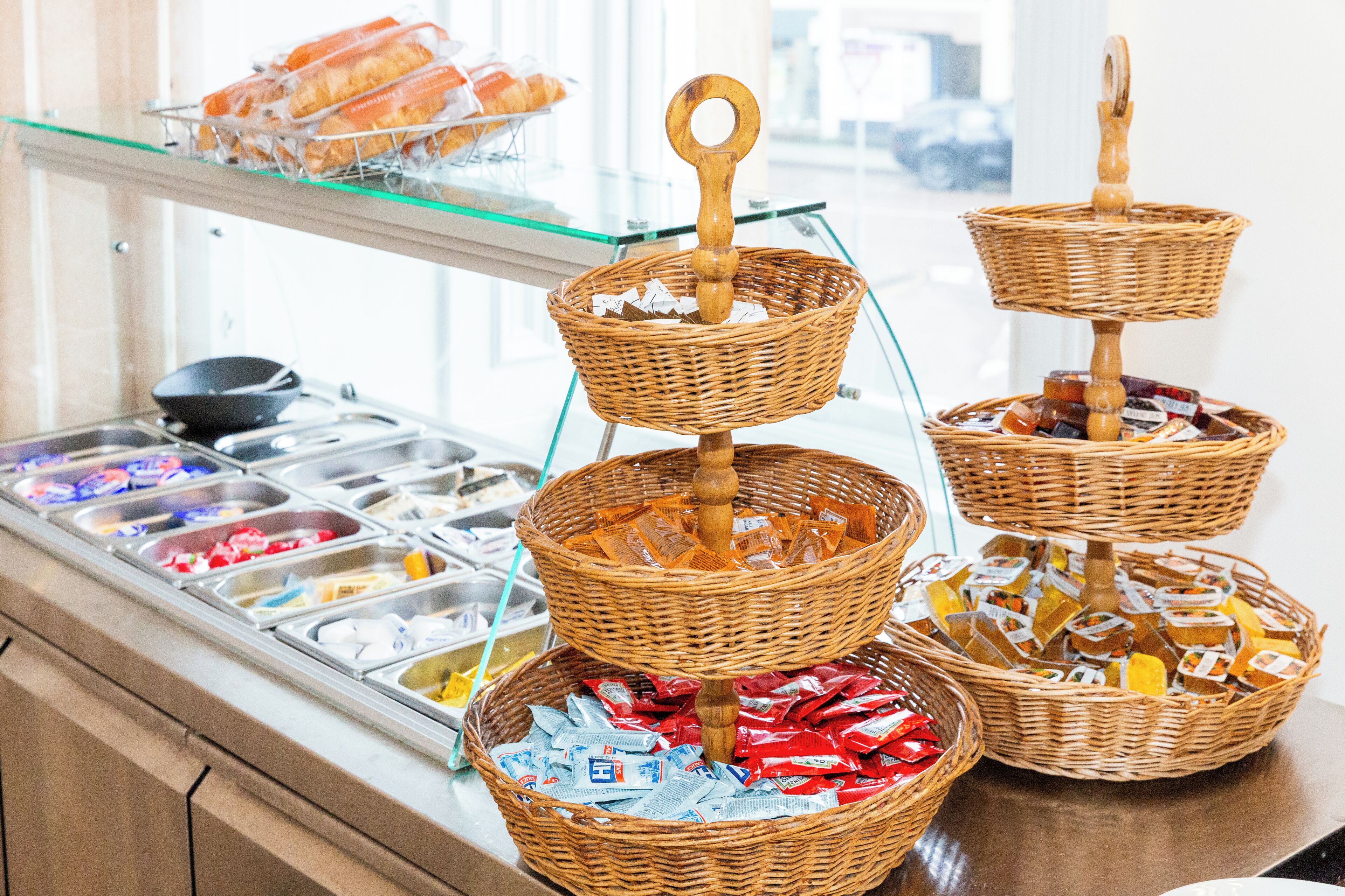 A buffet with multiple wicker baskets containing various food items.