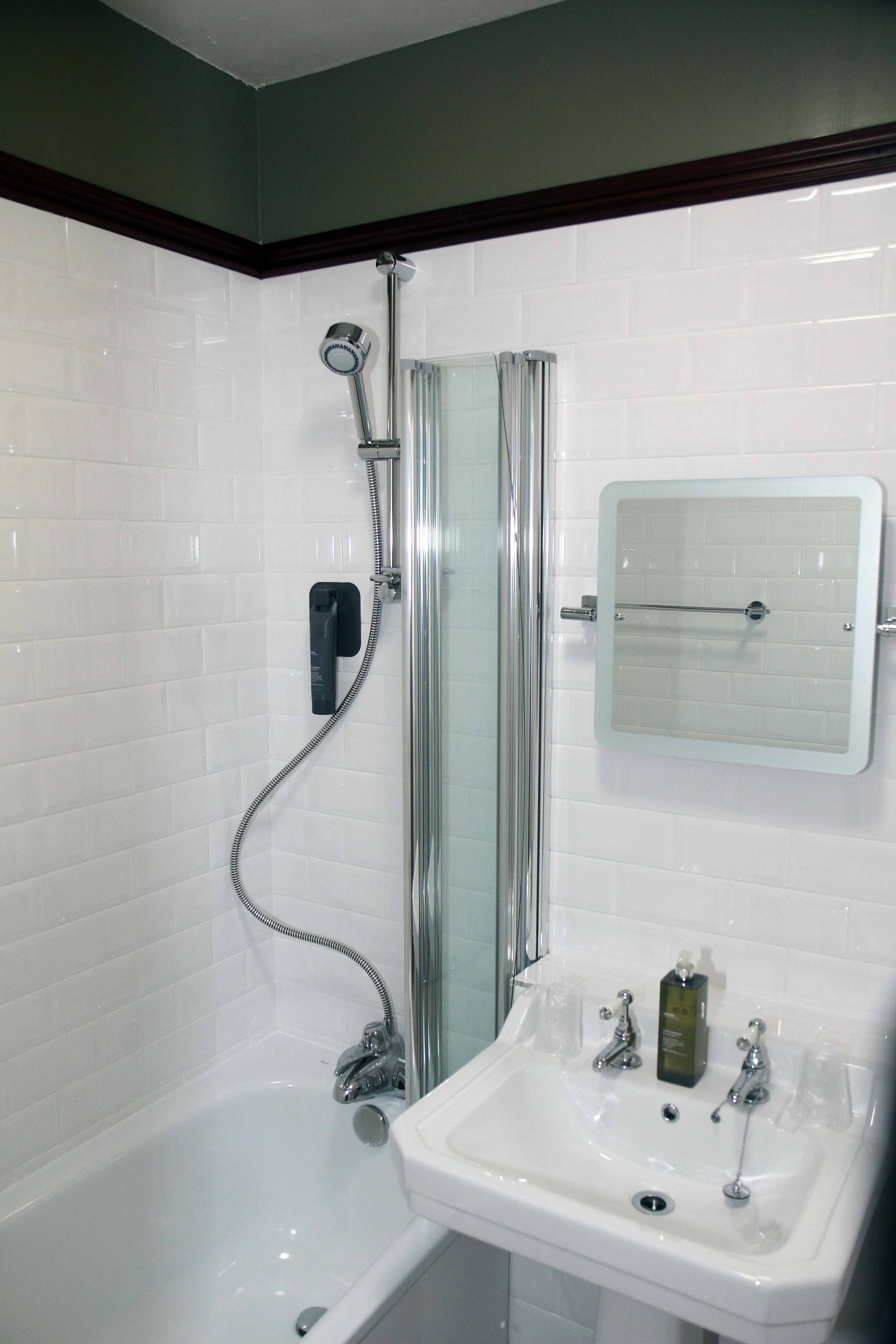 A bathroom with a shower, a sink, and a mirror.