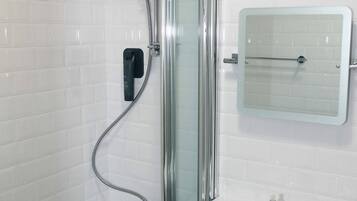 A bathroom with a shower, a sink, and a mirror.
